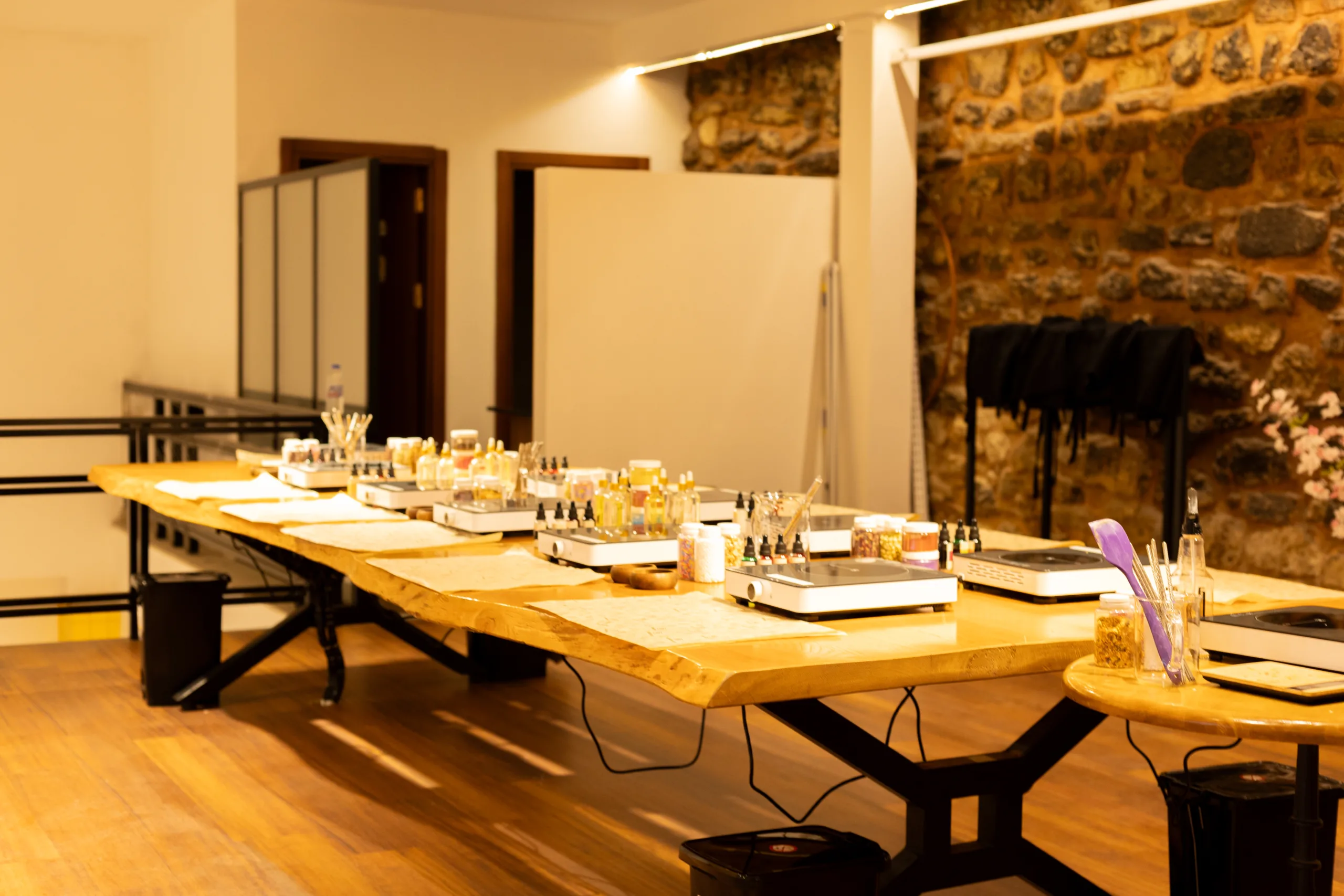 General view of Atölye Paşa — long wooden table, stone wall, and hanging aprons